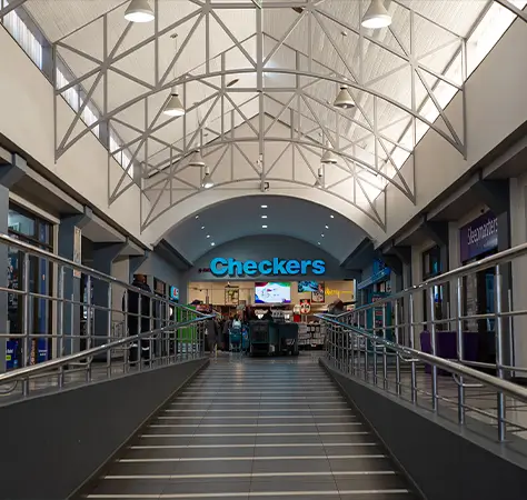 Interior walkway of Balfour Park Shopping Centre showing glass ceiling, handrails, and Checkers store entrance